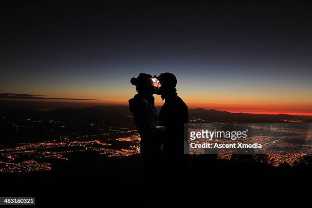 couple wearing headlamps kiss above city lights - santiago chile stock pictures, royalty-free photos & images