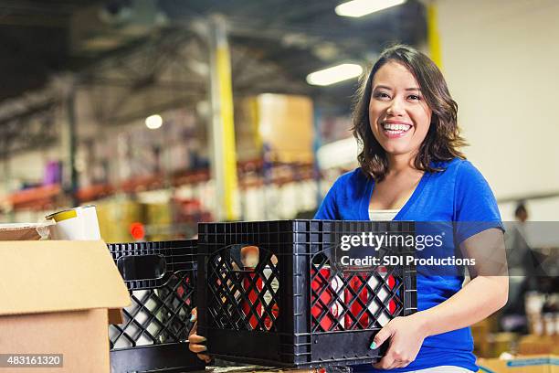 young asian american freiwilligen arbeitet in food bank warehouse - food service occupation stock-fotos und bilder