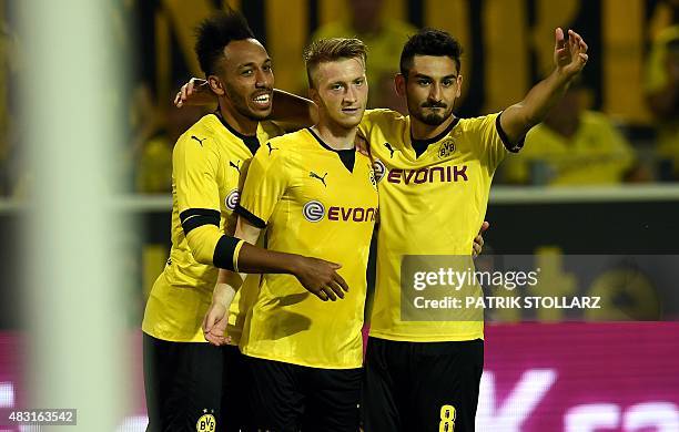 Dortmund's midfielder Ilkay Guendogan , Dortmund's striker Marco Reus and Dortmund's Gabonese striker Pierre-Emerick Aubameyang celebrate after Reus...