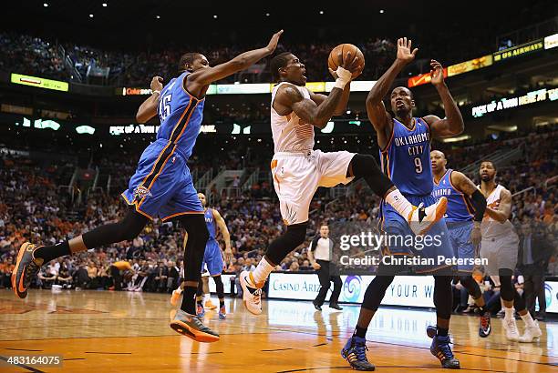 Eric Bledsoe of the Phoenix Suns drives to the basket past Kevin Durant and Serge Ibaka of the Oklahoma City Thunder during the second half of the...