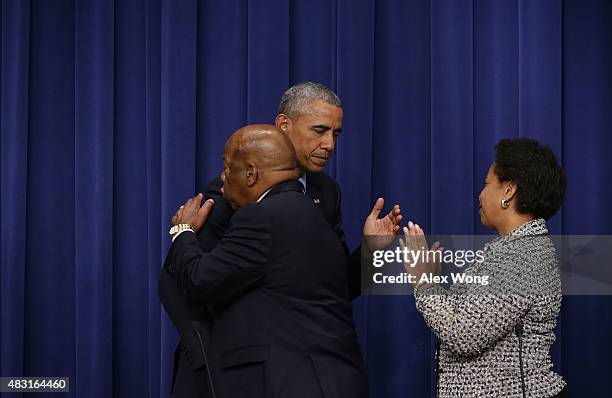 President Barack Obama hugs Rep. John Lewis as Attorney General Loretta Lynch looks on during an event at the South Court Auditorium of the...