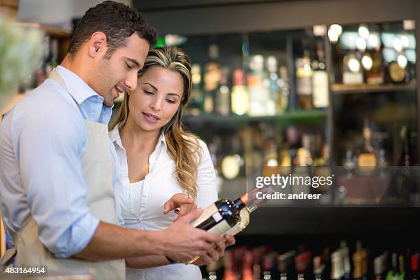 woman buying wine at the supermarket - buy single word stock pictures, royalty-free photos & images