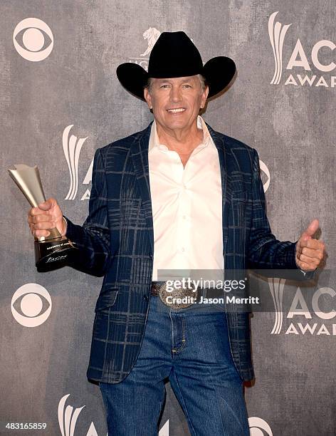 Singer/songwriter George Strait poses in the press room with the Entertainer of the Year award during the 49th Annual Academy of Country Music Awards...