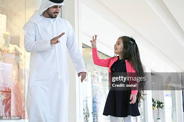 arab family in shopping center with bags - qatari family stockfoto's en -beelden