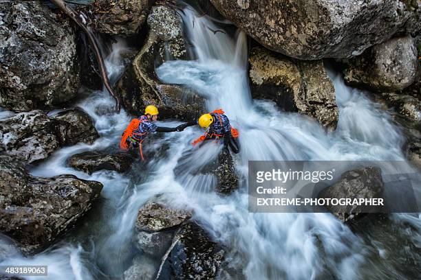 dangerous waterfall crossing - canyoning stock pictures, royalty-free photos & images