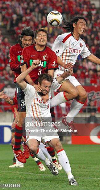 Joshua Kennedy of Nagoya Grampus and Daiki Iwamasa of Kashima Antlers compete for the ball during the J.League match between Kashima Antlers and...