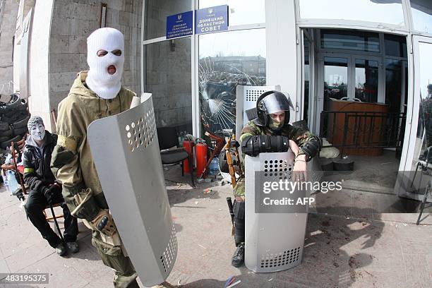 Pro-Russian activists guard a barricade set at the Donetsk regional council office building on the eastern city of Donetsk on April 7, 2014....