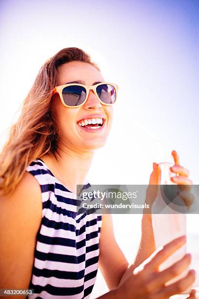 cheerful woman having a cool drink - blue sunglasses stock pictures, royalty-free photos & images