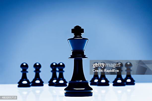 low angle shot of chess king with pawns in background - army navy game stock pictures, royalty-free photos & images
