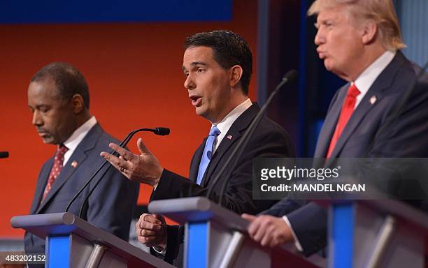 Wisconsin Governor Scott Walker , retired neurosurgeon Ben Carson , and real estate tycoon Donald Trump participate in the Republican presidential...