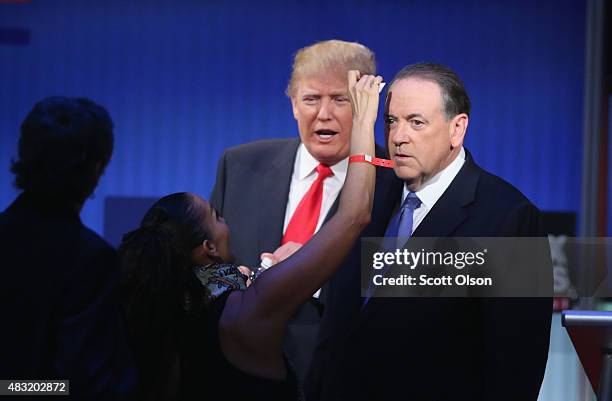 Republican presidential candidates Donald Trump and Mike Huckabee get their makeup retouched during a break in the first Republican presidential...