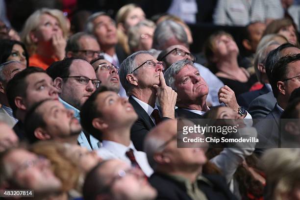 Audience members look up at the large video screen hanging abouve the first prime-time Republican presidential debate hosted by FOX News and Facebook...