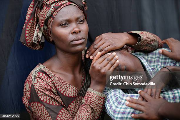 Woman consoles Bizimana Emmanuel during the 20th anniversary commemoration of the 1994 genocide at Amahoro Stadium April 7, 2014 in Kigali, Rwanda....