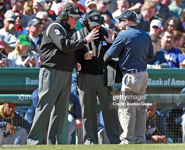 Umpires Tim Welke, left, and Tim Timmons, right, look at the instant replay of a second inning play at first base, where the Red Sox's Jackie Bradley...