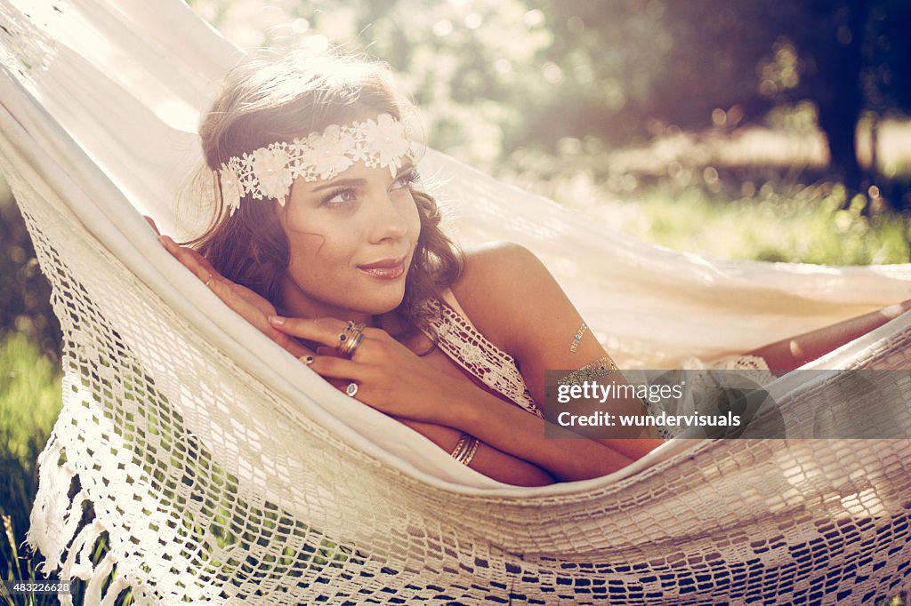 Beautiful girl in boho fashion headband in a summer hammock