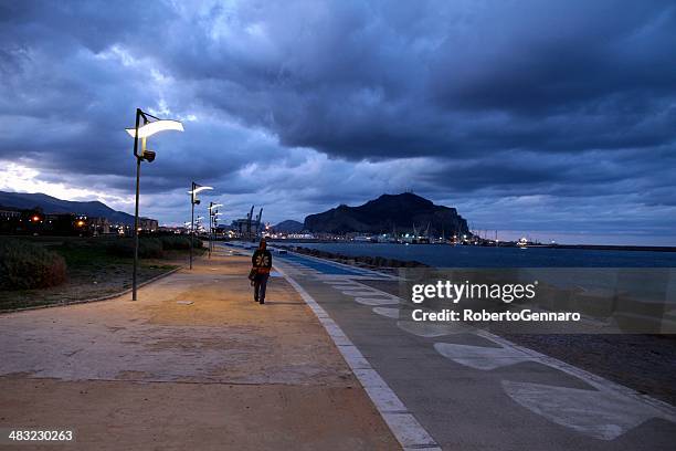 lonely walker at dusk cloudy sky palermo - gulf of palermo stock pictures, royalty-free photos & images