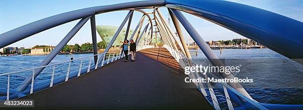 modern foot bridge to amsterdam's nemo science museum - nemo stock pictures, royalty-free photos & images