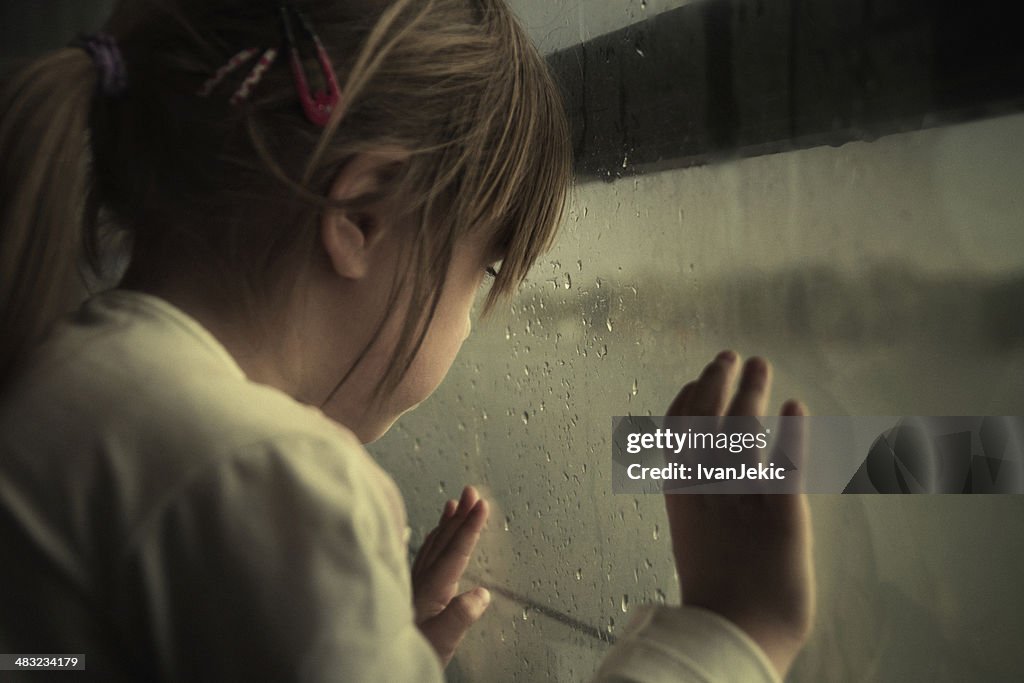 Einsames Kind Blick durchs Fenster