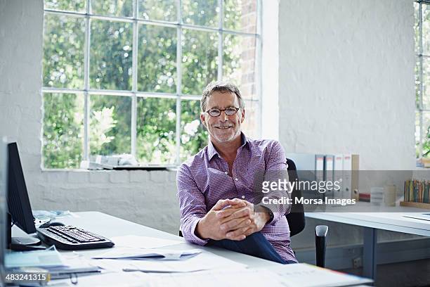 portrait of relaxed business man - older man in office stockfoto's en -beelden