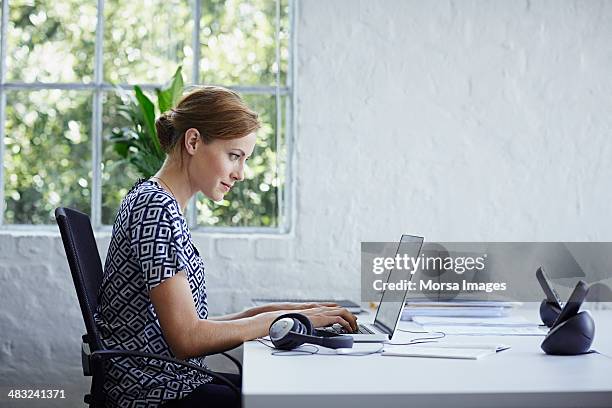 woman working on computer - female profile photos et images de collection