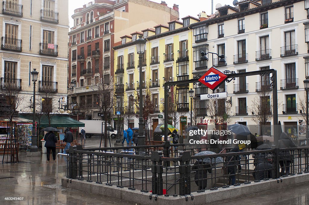People emerging from a Metro stop on a rainy day.