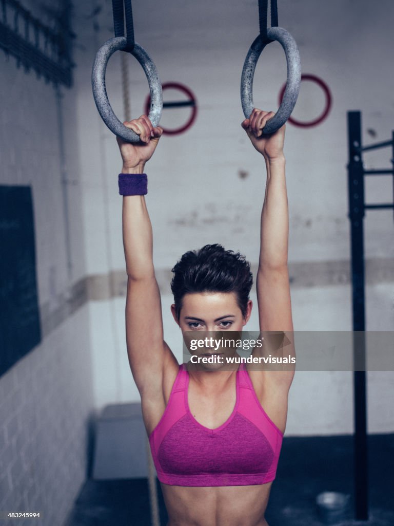 Girl about to do a pull-up on gymnastic rings