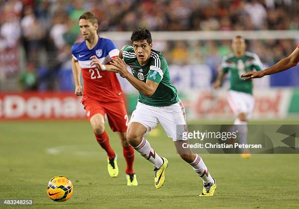 Raul Jimenez of Mexico controls the ball past Clarence Goodson of USA during the International Friendly at University of Phoenix Stadium on April 2,...