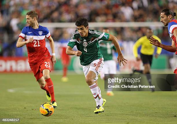 Raul Jimenez of Mexico controls the ball past Clarence Goodson of USA during the International Friendly at University of Phoenix Stadium on April 2,...