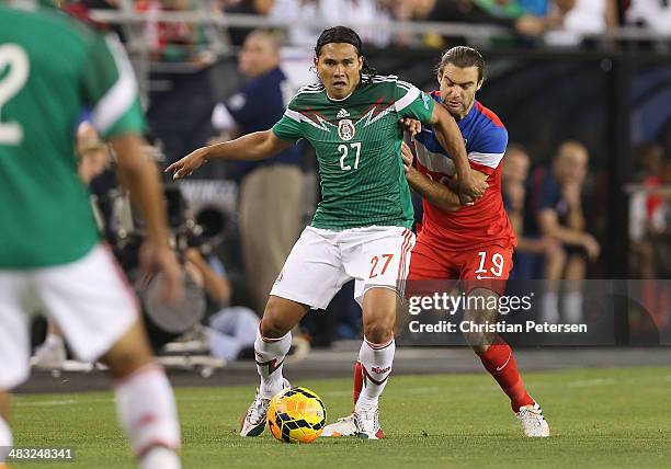 Carlos Alberto Pena of Mexico controls the ball ahead of Graham Zusi of USA during the International Friendly at University of Phoenix Stadium on...