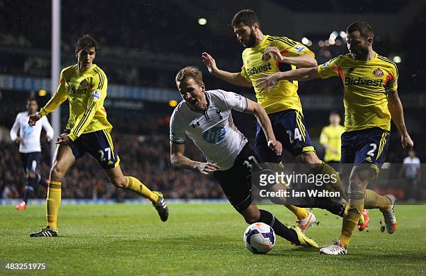 Harry Kane of Tottenham Hotspur goes to ground in the penalty area after a challenge from Carlos Cuellar and Phil Bardsley of Sunderland during the...