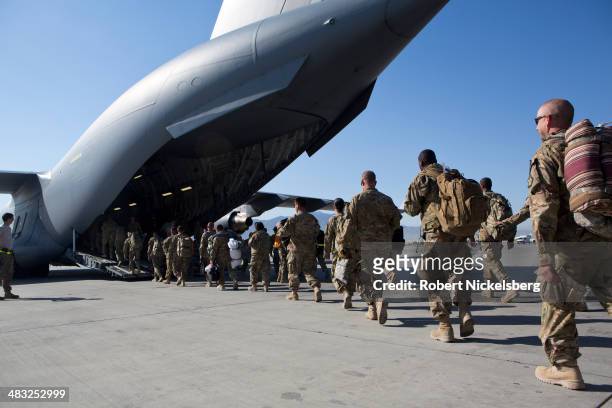 Army soldiers walk to their C-17 cargo plane for departure May 11, 2013 at Bagram Air Base, Afghanistan. U.S. Soldiers and marines are part of the...
