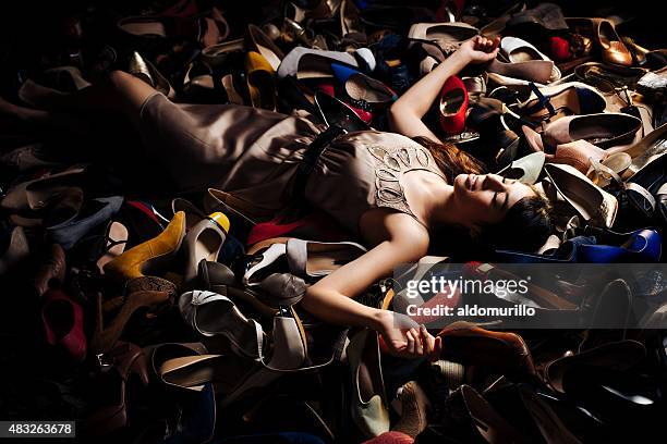 smiling woman lying on high heels - shopaholic stock pictures, royalty-free photos & images