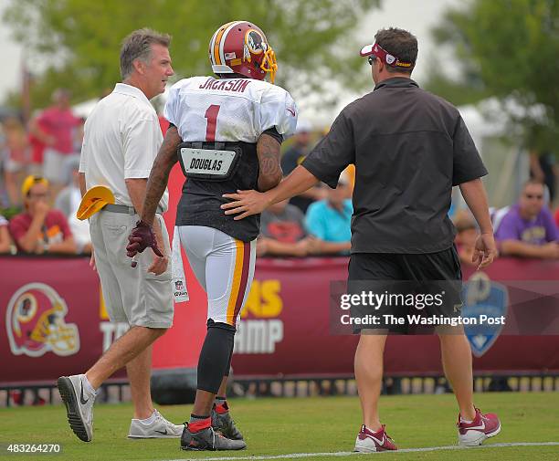 Washington wide receiver DeSean Jackson , center, walks off the field and is flanked by team president Bruce Allen, left and team trainer Larry Hess...