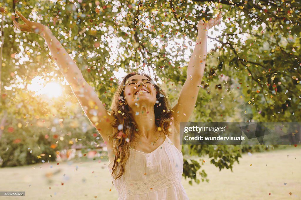 Young Woman throwing confetti in the park