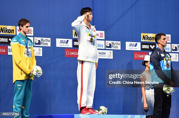 Ning Zetao of China salutes the national anthem after winning the Men's 100m Freestyle final during day thirteen of The 16th FINA World Swimming...