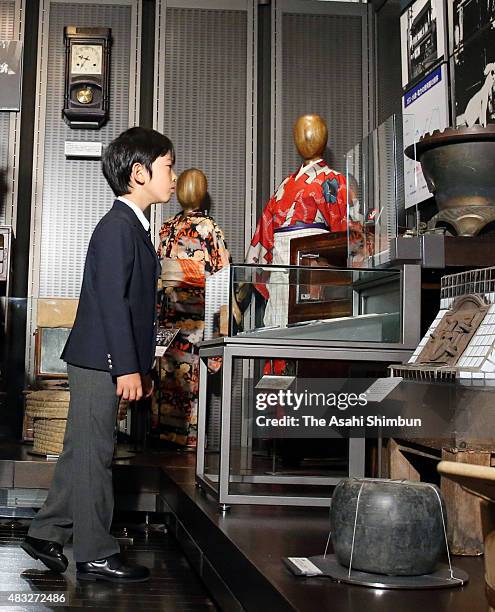 Prince Hisahito watches exhibits during his visit to the National Showa Memorial Museum ahead of the 70th anniversary of Japan's WWII surrender on...