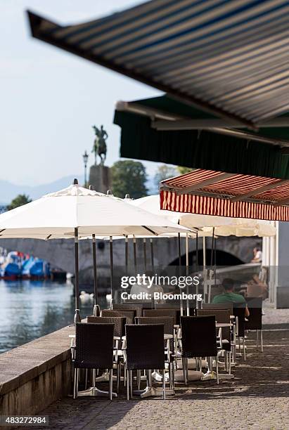 Cafe tables sit empty at a restaurant terrace on the bank of the Limmat river in downtown Zurich, Switzerland, on Thursday, Aug. 6, 2015. Swiss...