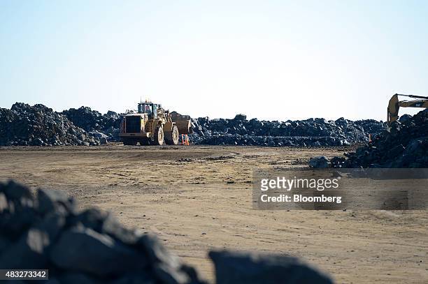 Front loader transports ore in the storage ground at Evolution Mining Ltd.'s gold operations in Mungari, Australia, on Wednesday, Aug. 5, 2015. A...