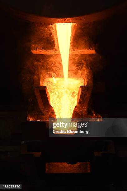 Molten gold pours from a crucible into molds at Evolution Mining Ltd.'s gold operations in Mungari, Australia, on Wednesday, Aug. 5, 2015. A...