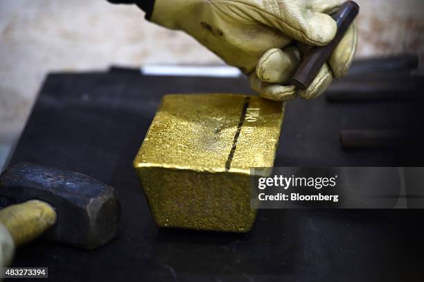 Bar of gold is manually stamped at Evolution Mining Ltd.'s gold operations in Mungari, Australia, on Wednesday, Aug. 5, 2015. A declining gold price,...