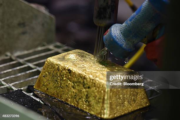 Bar of gold is cleaned with a pin needle drill at Evolution Mining Ltd.'s gold operations in Mungari, Australia, on Wednesday, Aug. 5, 2015. A...