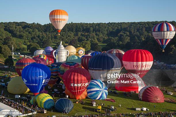 Hot air balloons rise into the morning sky from the Bristol International Balloon Fiesta main arena at the Ashton Court estate on August 7, 2015 in...