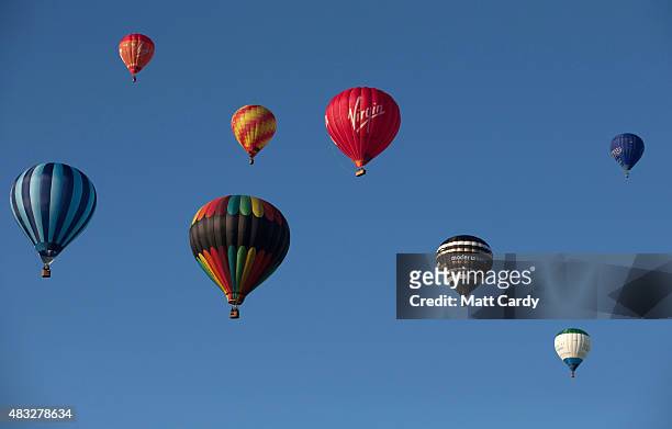 Hot air balloons rise into the morning sky from the Bristol International Balloon Fiesta main arena at the Ashton Court estate on August 7, 2015 in...