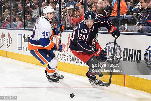 Matt Frattin of the Columbus Blue Jackets skates with the puck as Matt Donovan of the New York Islanders defends on April 6, 2014 at Nationwide Arena...