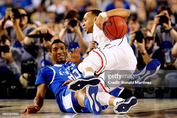 Shabazz Napier of the Connecticut Huskies falls to the ground as Marcus Lee of the Kentucky Wildcats defends during the NCAA Men's Final Four...