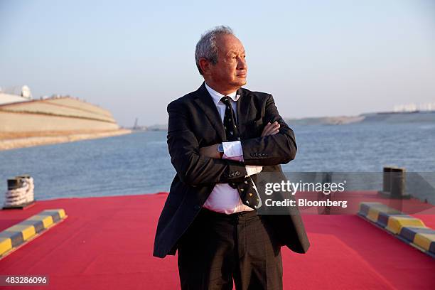 Egyptian billionaire Naguib Sawiris poses for a photograph on a floating pontoon in front of the New Suez Canal, operated by the Suez Canal...