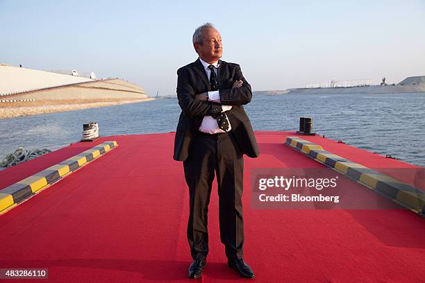 Egyptian billionaire Naguib Sawiris poses for a photograph on a floating pontoon in front of the New Suez Canal, operated by the Suez Canal...