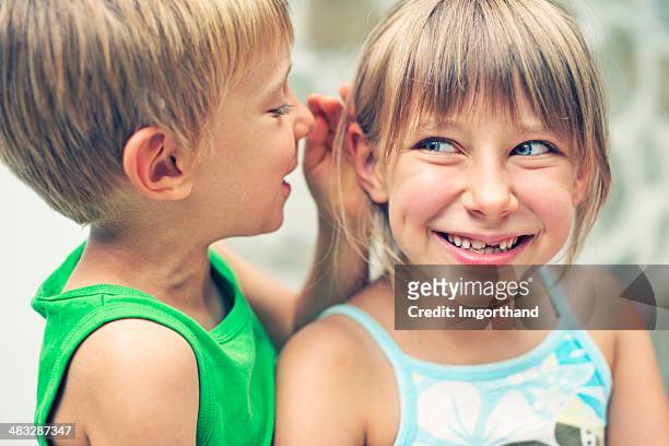 funny little secrets - child whispering stockfoto's en -beelden