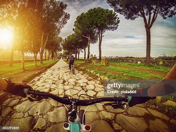 mountain bike auf der via appia antica und aqueduct - antica roma stock-fotos und bilder