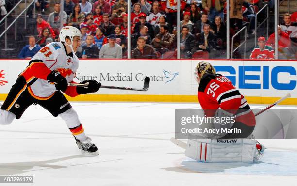 Kenny Agostino of the Calgary Flames is stopped on a breakaway by Cory Schneider of the New Jersey Devils during the game at the Prudential Center on...